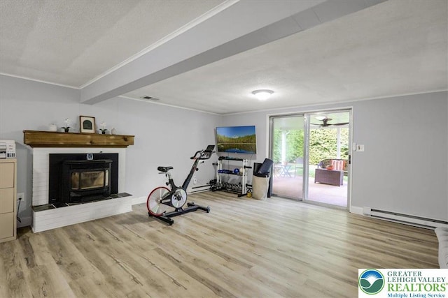 812 Miller St, Salisbury Twp, PA 18103 - workout area featuring a baseboard radiator, crown molding, wood finished floors, a textured ceiling, and a fireplace