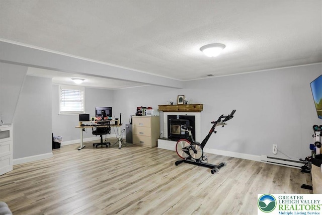 812 Miller St, Salisbury Twp, PA 18103 - exercise room featuring wood finished floors, a baseboard heating unit, a glass covered fireplace, and a textured ceiling