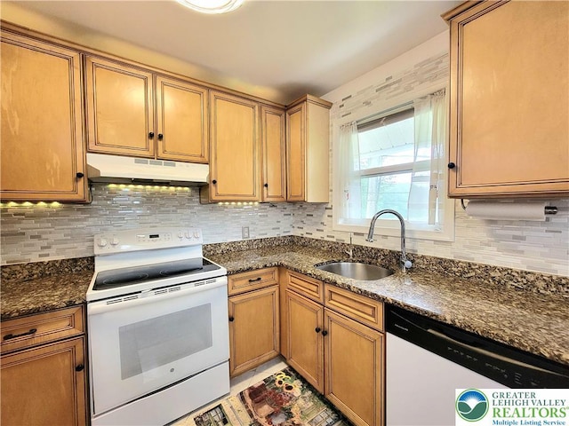 1025 Cricket Ln, Tobyhanna Twp, PA 18334 - kitchen with white appliances, under cabinet range hood, backsplash, and dark stone counters