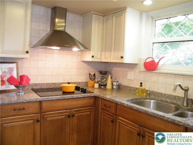 3415 Kathleen Ave, Salisbury Twp, PA 18103 - kitchen with wall chimney range hood, decorative backsplash, black electric stovetop, brown cabinetry, and stone counters