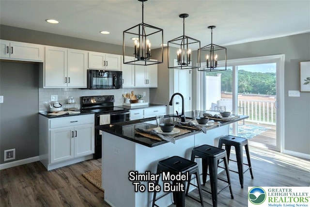 3229 Tepes Dr Lot 138, Allen Twp, PA 18067 - kitchen with black appliances, white cabinetry, a kitchen bar, wood finished floors, and dark countertops