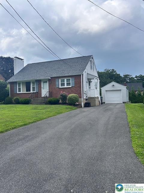 2653 Woodlawn Ave, Palmer Twp, PA 18045 - view of front of property with asphalt driveway, a detached garage, an outbuilding, a chimney, and brick siding