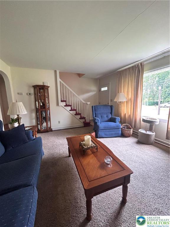 2653 Woodlawn Ave, Palmer Twp, PA 18045 - living room featuring carpet, stairway, and arched walkways