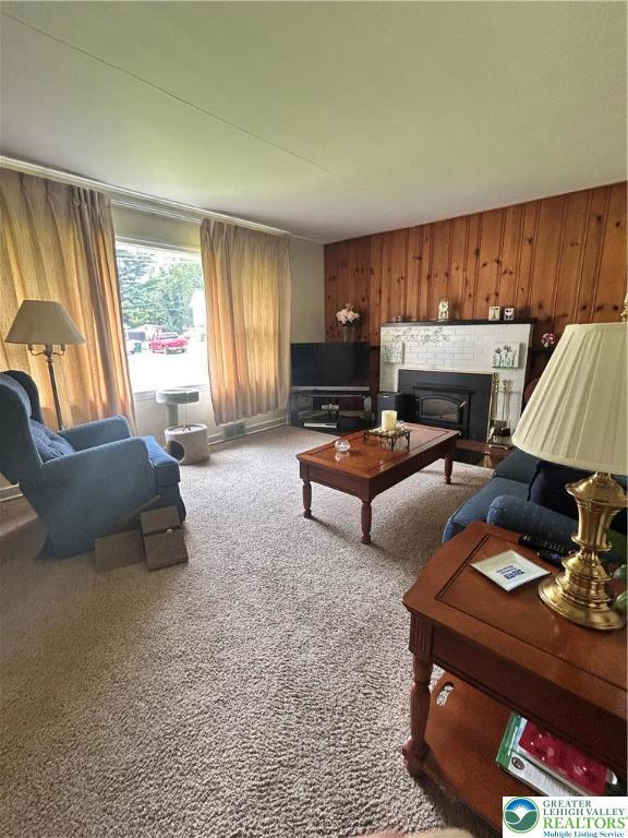 2653 Woodlawn Ave, Palmer Twp, PA 18045 - living room featuring wooden walls, carpet floors, and a glass covered fireplace