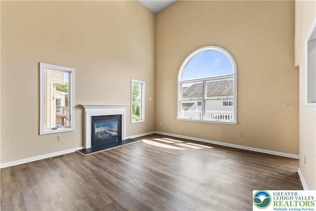 9 Stone Crk, Palmer Twp, PA 18045 - unfurnished living room with wood finished floors, a glass covered fireplace, and a high ceiling