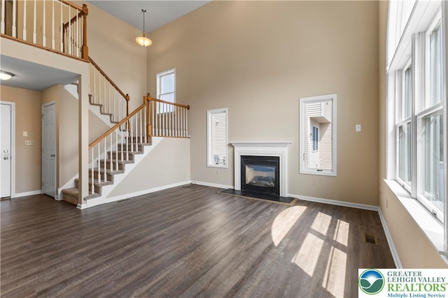 9 Stone Crk, Palmer Twp, PA 18045 - unfurnished living room with a towering ceiling, stairs, dark wood finished floors, and a fireplace