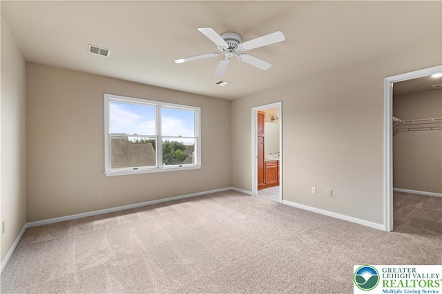 9 Stone Crk, Palmer Twp, PA 18045 - unfurnished bedroom with light colored carpet, a walk in closet, ensuite bath, and a ceiling fan