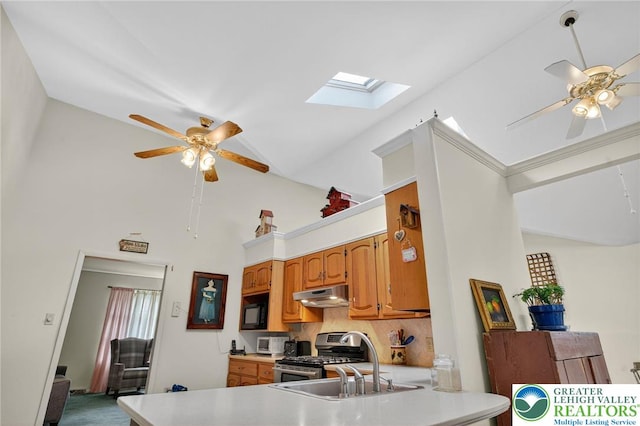 56 Hearthstone Dr, Exeter Twp, PA 19606 - kitchen with ceiling fan, stainless steel gas range, under cabinet range hood, a skylight, and high vaulted ceiling