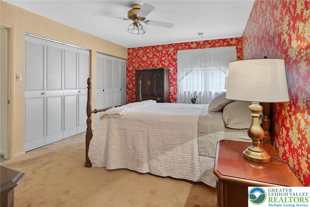 56 Hearthstone Dr, Exeter Twp, PA 19606 - carpeted bedroom with wallpapered walls, two closets, and a ceiling fan