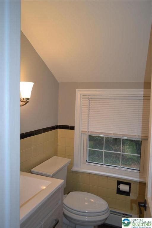 1424 Westgate Dr, Hanover Twp, PA 18017 - bathroom with tile walls, vaulted ceiling, a baseboard radiator, vanity, and wainscoting