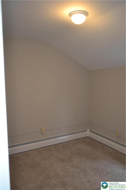 1424 Westgate Dr, Hanover Twp, PA 18017 - empty room featuring carpet floors, a baseboard heating unit, and vaulted ceiling