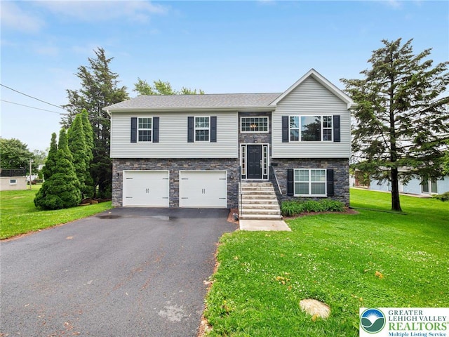 317 Fairview Ave, Wind Gap Boro, PA 18091 - bi-level home with asphalt driveway, an attached garage, stone siding, and a front yard
