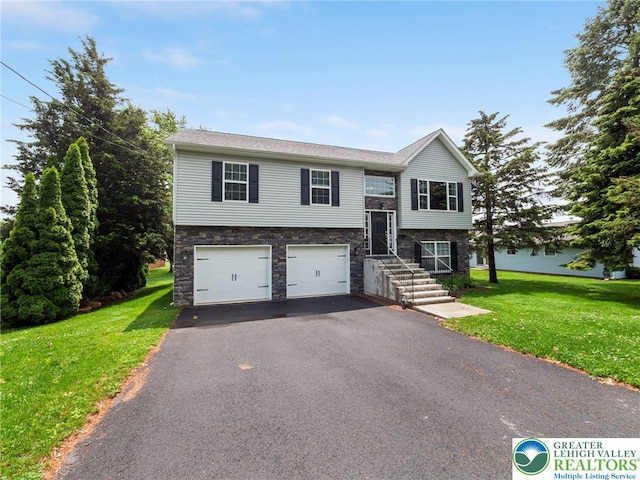 317 Fairview Ave, Wind Gap Boro, PA 18091 - split foyer home featuring asphalt driveway, an attached garage, a front lawn, and stone siding