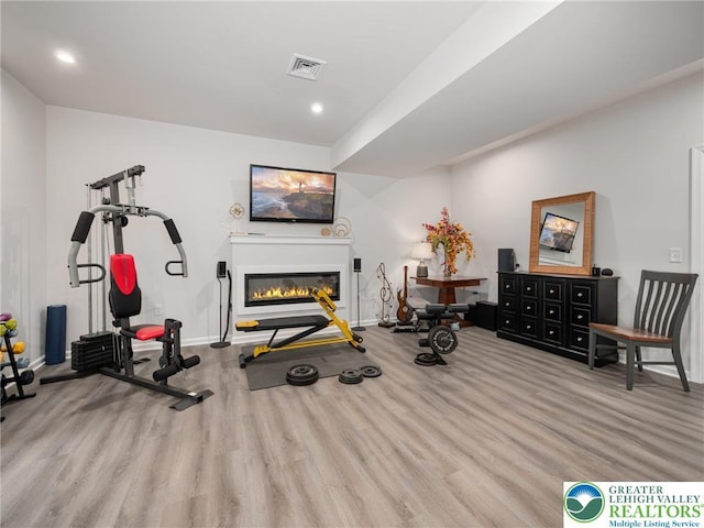 317 Fairview Ave, Wind Gap Boro, PA 18091 - exercise area featuring wood finished floors, a glass covered fireplace, and recessed lighting