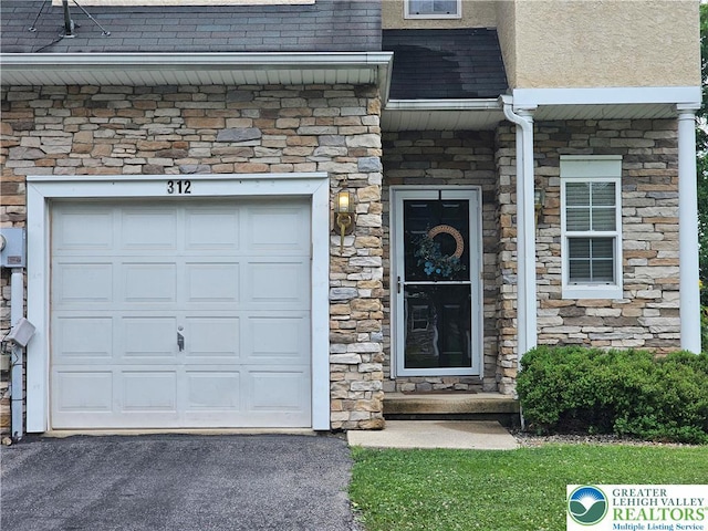 312 Maple Ct, Alburtis Boro, PA 18011 - view of exterior entry with stone siding, a shingled roof, and stucco siding