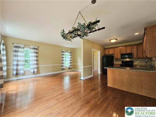 312 Maple Ct, Alburtis Boro, PA 18011 - kitchen with healthy amount of natural light, black appliances, wood finished floors, and dark stone countertops