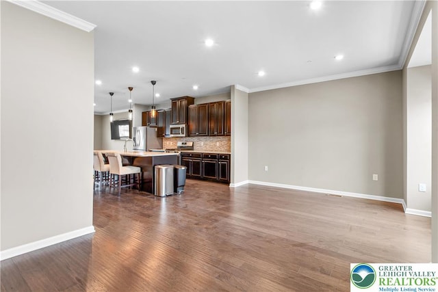 2324 Raya Way, Easton, PA 18045 - kitchen with a breakfast bar area, light countertops, a center island with sink, wood finished floors, and ornamental molding