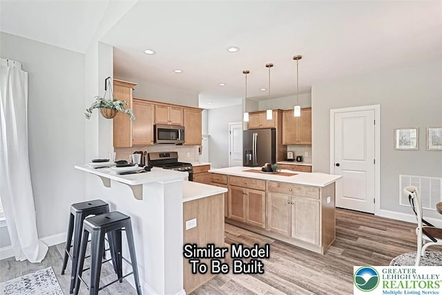 Bambi Ln Lot 40, Mahoning Twp, PA 18235 - kitchen with stainless steel appliances, wood finished floors, light brown cabinetry, a breakfast bar, and decorative backsplash