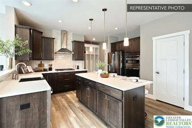Bambi Ln Lot 40, Mahoning Twp, PA 18235 - kitchen featuring tasteful backsplash, dark brown cabinetry, wall chimney range hood, light wood-type flooring, and recessed lighting