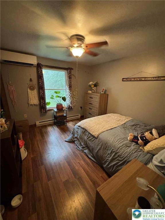 15 Hiawatha Trl, Penn Forest Twp, PA 18210 - bedroom with wood finished floors, an AC wall unit, and a ceiling fan