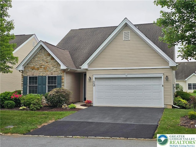 15 Devonshire Dr, Palmer Twp, PA 18045 - view of front of house featuring asphalt driveway, an attached garage, stone siding, and a shingled roof