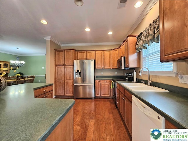 15 Devonshire Dr, Palmer Twp, PA 18045 - kitchen featuring appliances with stainless steel finishes, dark countertops, brown cabinets, dark wood-style floors, and crown molding