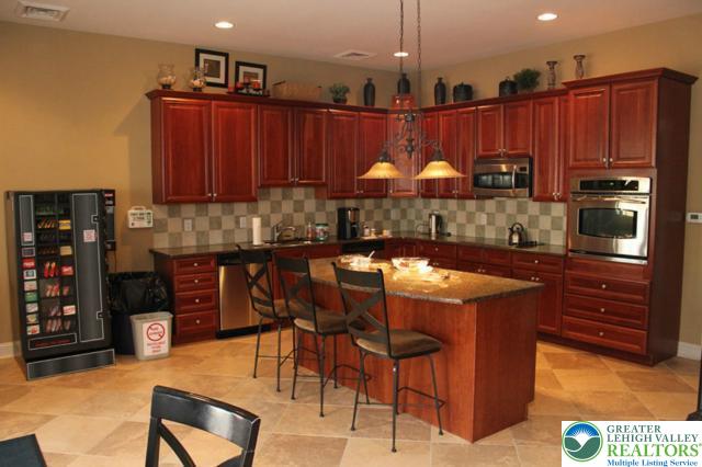 15 Devonshire Dr, Palmer Twp, PA 18045 - kitchen with dark brown cabinets, appliances with stainless steel finishes, decorative backsplash, a kitchen breakfast bar, and a kitchen island