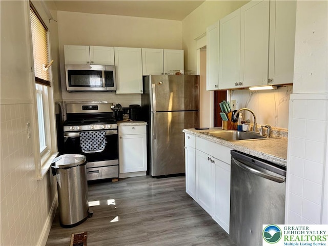 926 Delaware Ave, Fountain Hill Boro, PA 18015 - kitchen with appliances with stainless steel finishes, light countertops, white cabinetry, wood finished floors, and tile walls