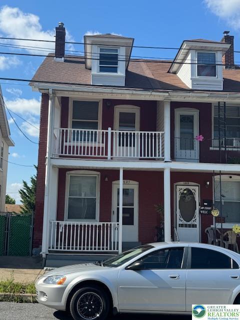 1627 E 8th Th, Bethlehem City, PA 18015 - view of front of home with a chimney, a balcony, and roof with shingles