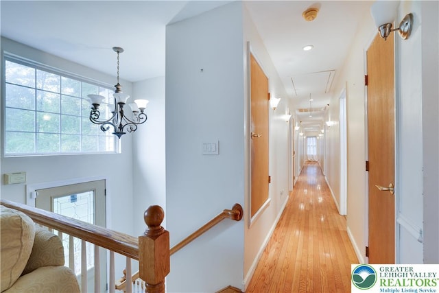 303 Lakefield Ter, Jackson Twp, PA 18360 - corridor featuring attic access, light wood-type flooring, an upstairs landing, and a chandelier