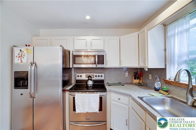 303 Lakefield Ter, Jackson Twp, PA 18360 - kitchen featuring appliances with stainless steel finishes, white cabinets, light countertops, decorative backsplash, and recessed lighting
