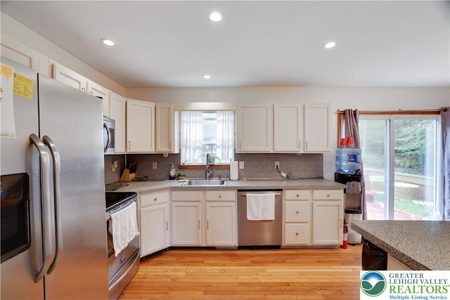 303 Lakefield Ter, Jackson Twp, PA 18360 - kitchen with stainless steel appliances, tasteful backsplash, light wood-style floors, white cabinetry, and recessed lighting