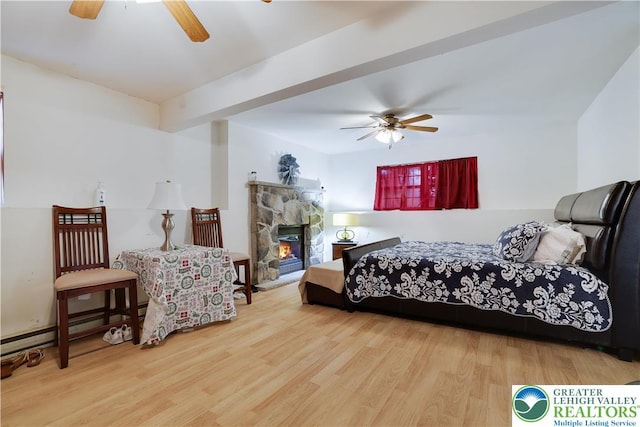 303 Lakefield Ter, Jackson Twp, PA 18360 - bedroom featuring wood finished floors, a baseboard heating unit, a stone fireplace, and ceiling fan
