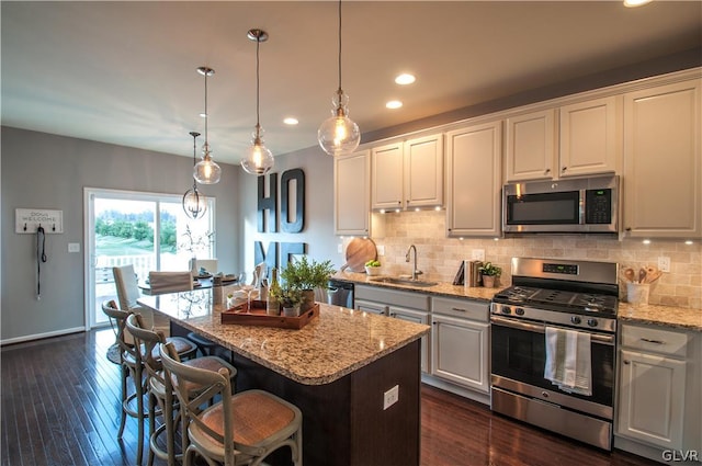 kitchen with white cabinets, a center island, dark hardwood / wood-style flooring, stainless steel appliances, and sink