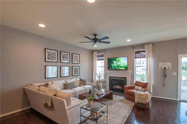 living room featuring wood-type flooring, a healthy amount of sunlight, and ceiling fan