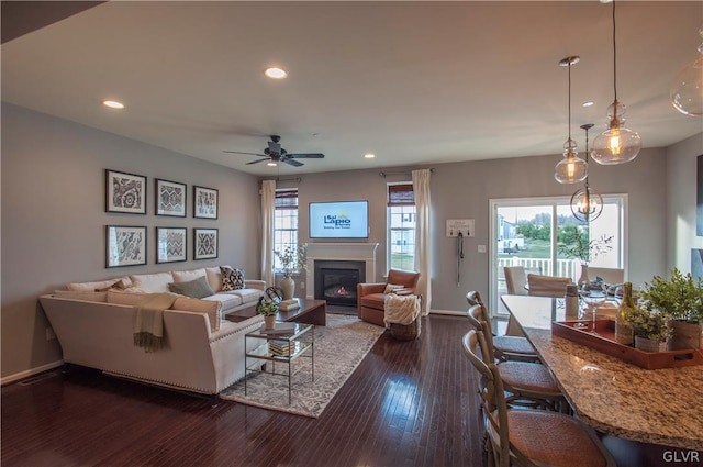 living room with dark wood-type flooring and ceiling fan