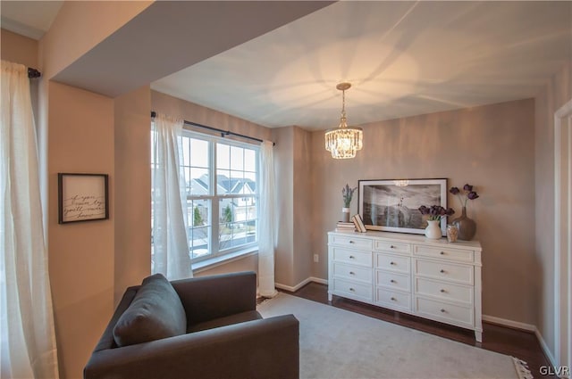 sitting room with dark hardwood / wood-style floors and a notable chandelier