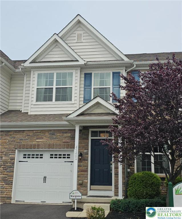 4548 Woodbrush Unit 311Model, Home, Upper Macungie Twp, PA 18104 - view of front of home with an attached garage, stone siding, asphalt driveway, and a shingled roof