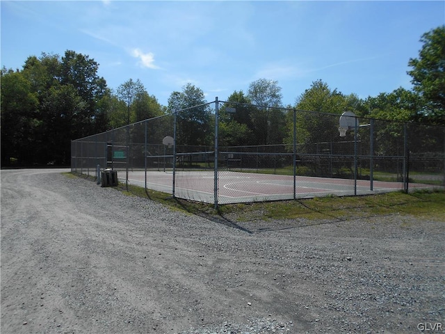 view of tennis court featuring basketball hoop