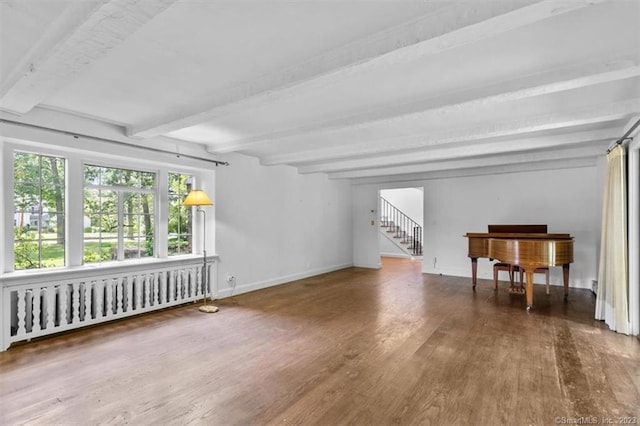 empty room featuring radiator heating unit, beam ceiling, and dark hardwood / wood-style floors