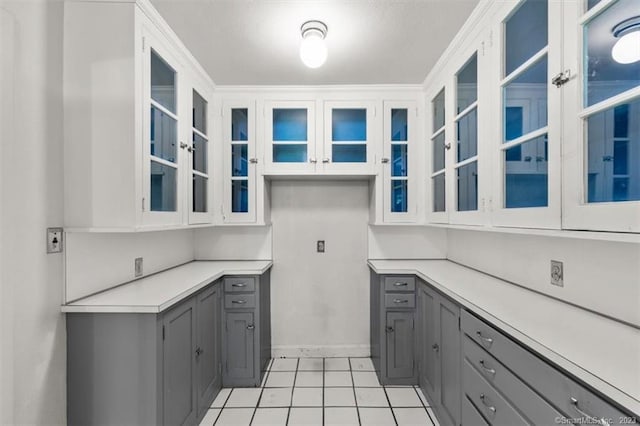 kitchen featuring gray cabinetry, white cabinetry, and light tile floors