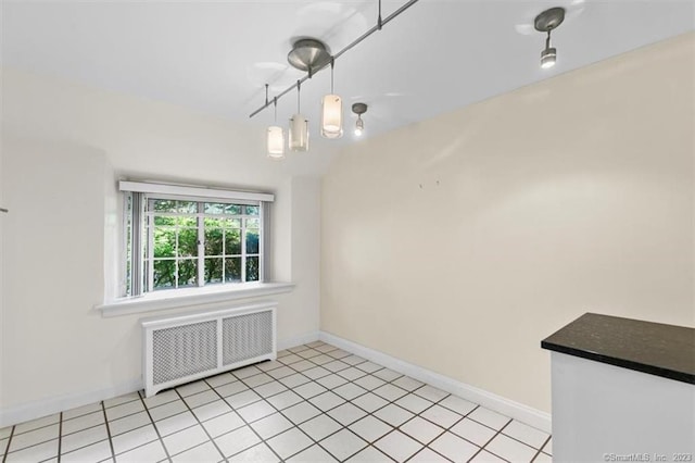 unfurnished room featuring radiator and light tile flooring