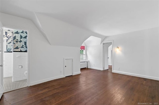 bonus room featuring radiator, dark hardwood / wood-style floors, and vaulted ceiling