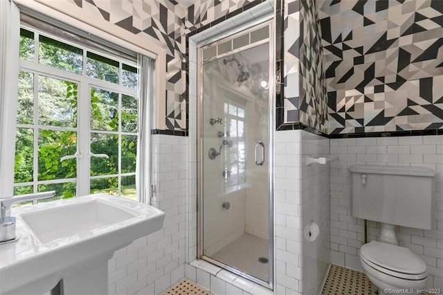 bathroom featuring toilet, a shower with shower door, tile walls, sink, and tile floors