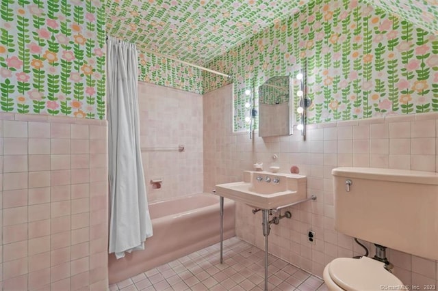 full bathroom with tile flooring, tile walls, shower / bath combination with curtain, and toilet