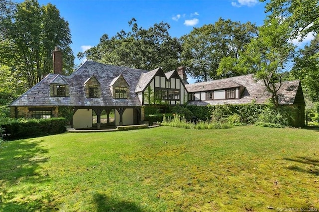 rear view of property featuring a lawn