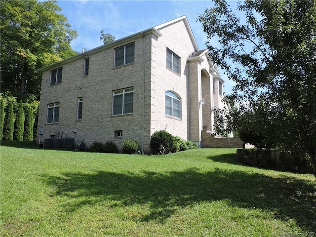 view of home's exterior with a lawn and central air condition unit