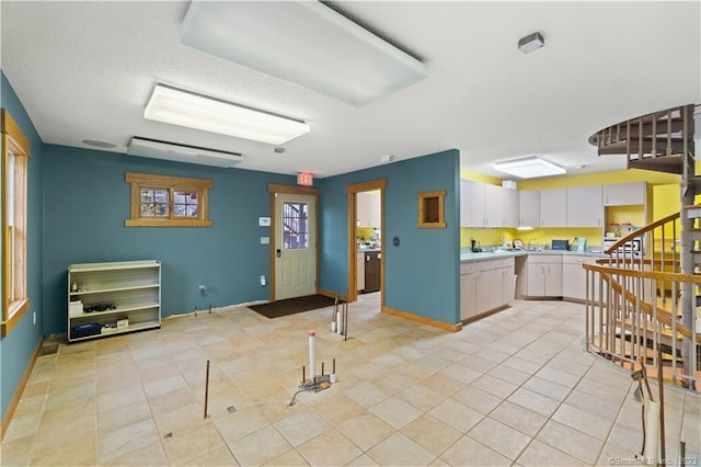 kitchen featuring light tile flooring and white cabinets