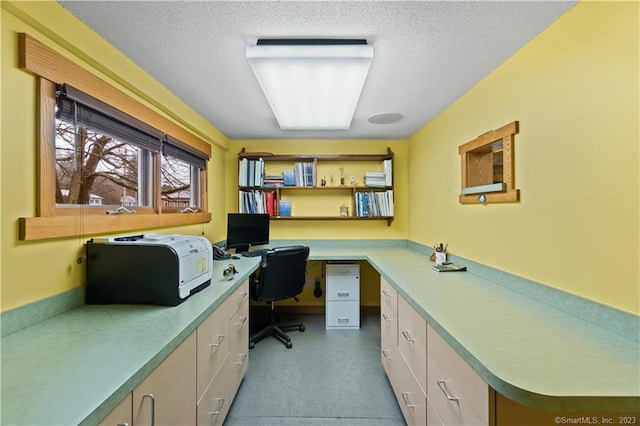 office area with built in desk and a textured ceiling