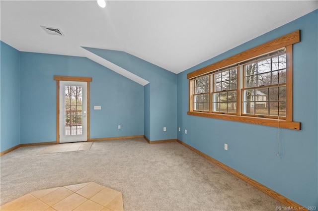 unfurnished room with lofted ceiling and light carpet